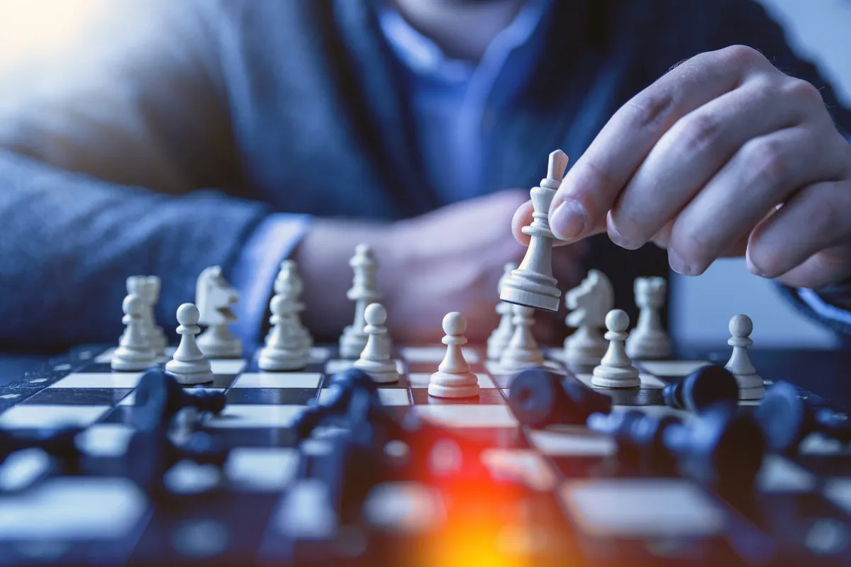A businessman considering his next move on a chess board